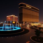 Wynn Resorts hotel exterior lit up at night with illuminated fountain in the foreground